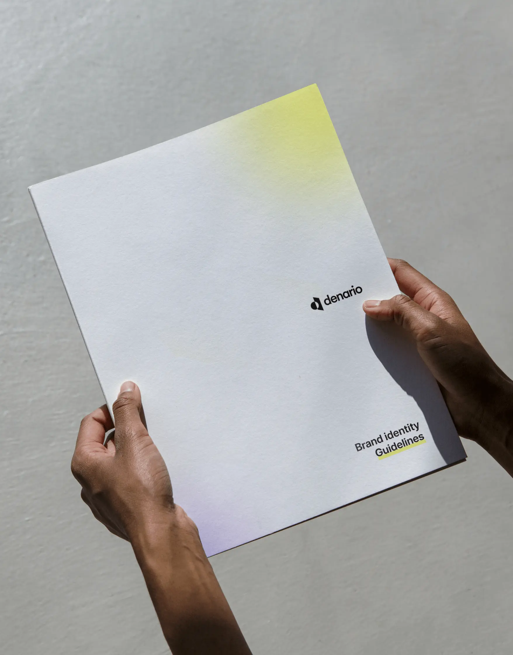 Hand holding a document with a Denario sticky note